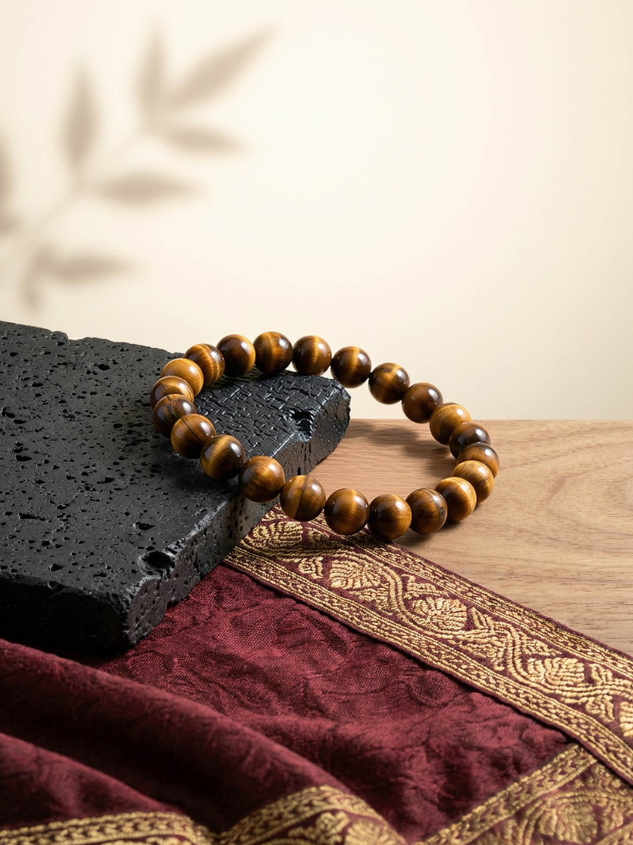 Angled lifestyle shot of the Concentration & Focus beaded stretch bracelet resting on a textured black stone against a warm, neutral background.
