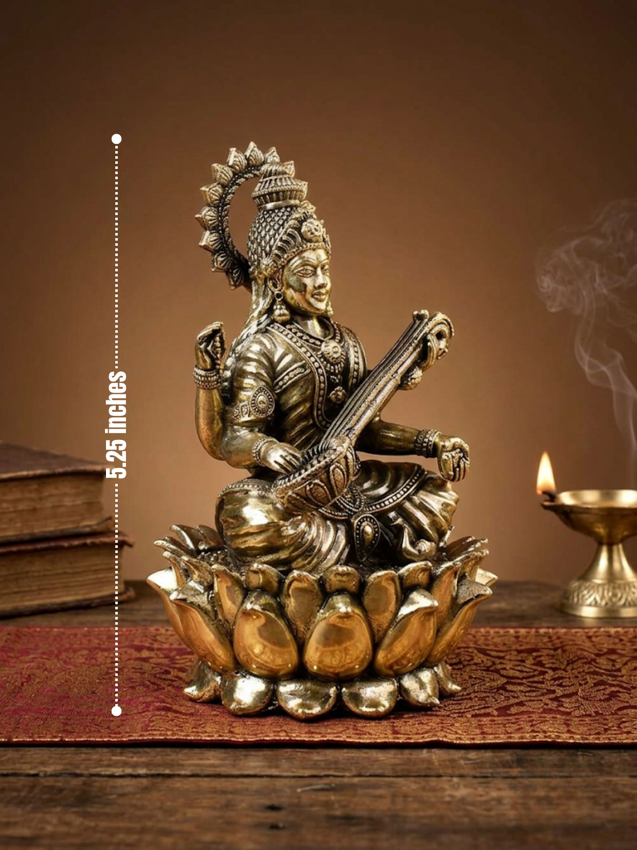 A metallic brass Lord Siva statue seated on a lotus base, playing a veena, displayed on a wooden surface with a warm brown background, books, and a burning diya. A vertical measurement marker indicates 5.