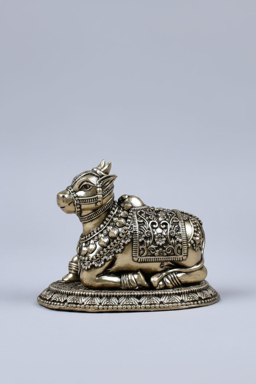 Decorative metal bull figurine on a beige surface with a red fabric background