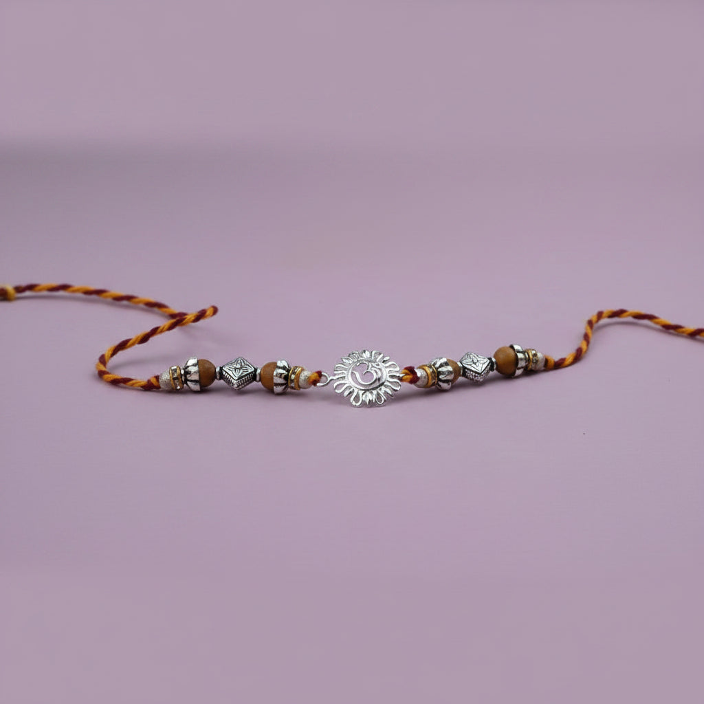 OM Design Rakhi in Pure Silver with Sandalwood Bead in thread - II